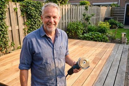 Het opgeknapte terras met de slijper in de hand