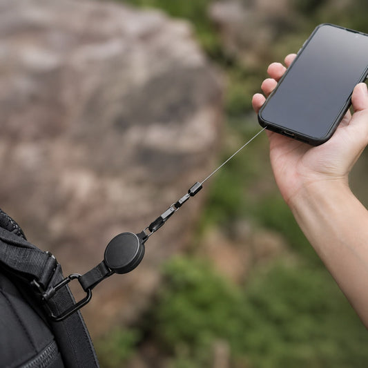 Belay anti-val telefoonkoord in gebruik - telefoon veilig aan het uitgerekte koord boven de rotsen