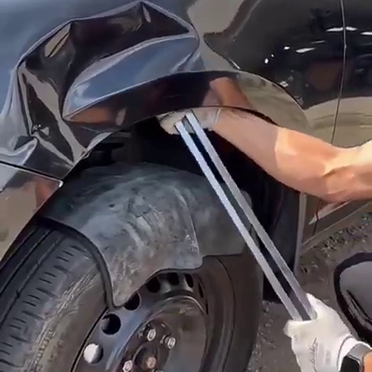 De Levar staaf gaat via de wielkastopening achter het gedeukte plaatwerk van een auto